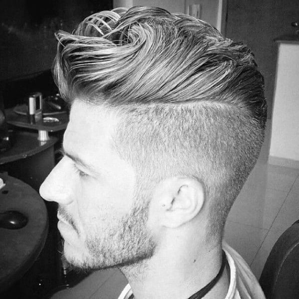 High-volume, textured quiff with a hard part and a clean fade