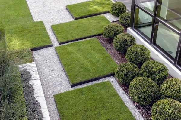 Modern garden with square grass patches, gravel pathways, and neatly trimmed boxwood shrubs.