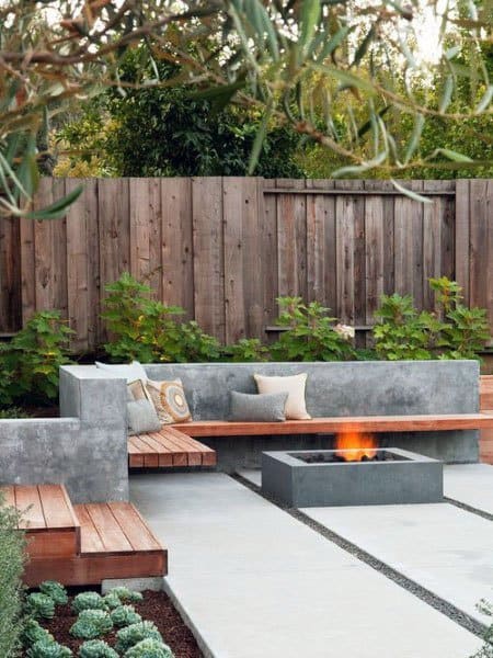 stylish concrete patio with wood seats and firepit