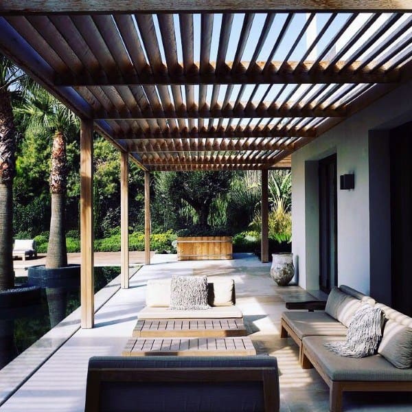 Modern pergola with wooden slats, sleek outdoor seating, and a poolside patio setting.
