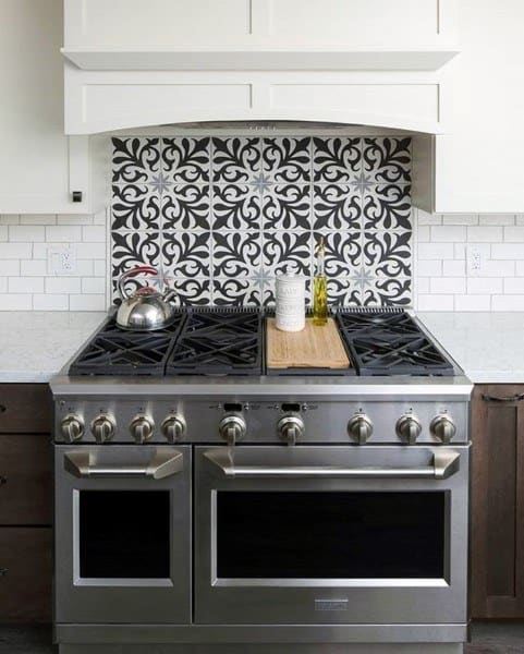 Bold patterned backsplash adds character above a stainless steel stove.