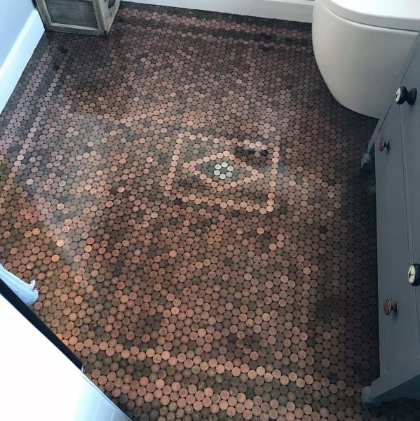 Bathroom with penny tile floor featuring a central diamond pattern and dark cabinetry.