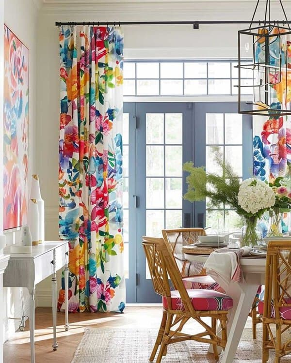 Vibrant dining room with colorful floral curtains, rattan chairs, and a bright, airy atmosphere.
