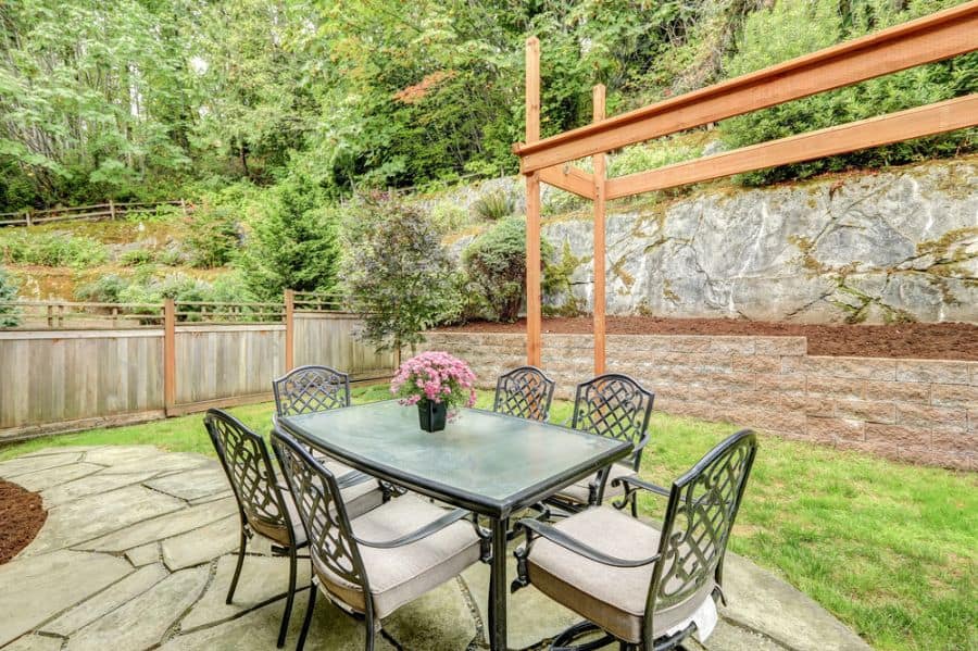 large backyard with small paver patio glass table and chairs