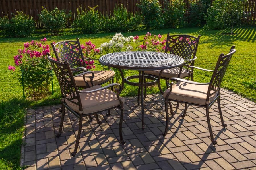 ornate metal table and chairs on brick paver patio