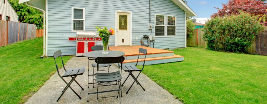 backyard cement patio with table and chairs