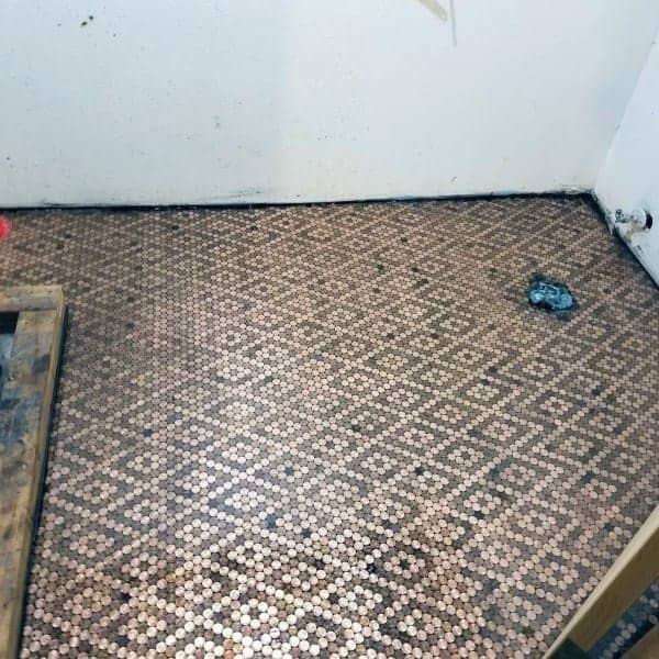 Room with penny tile flooring in a geometric diamond pattern under renovation.