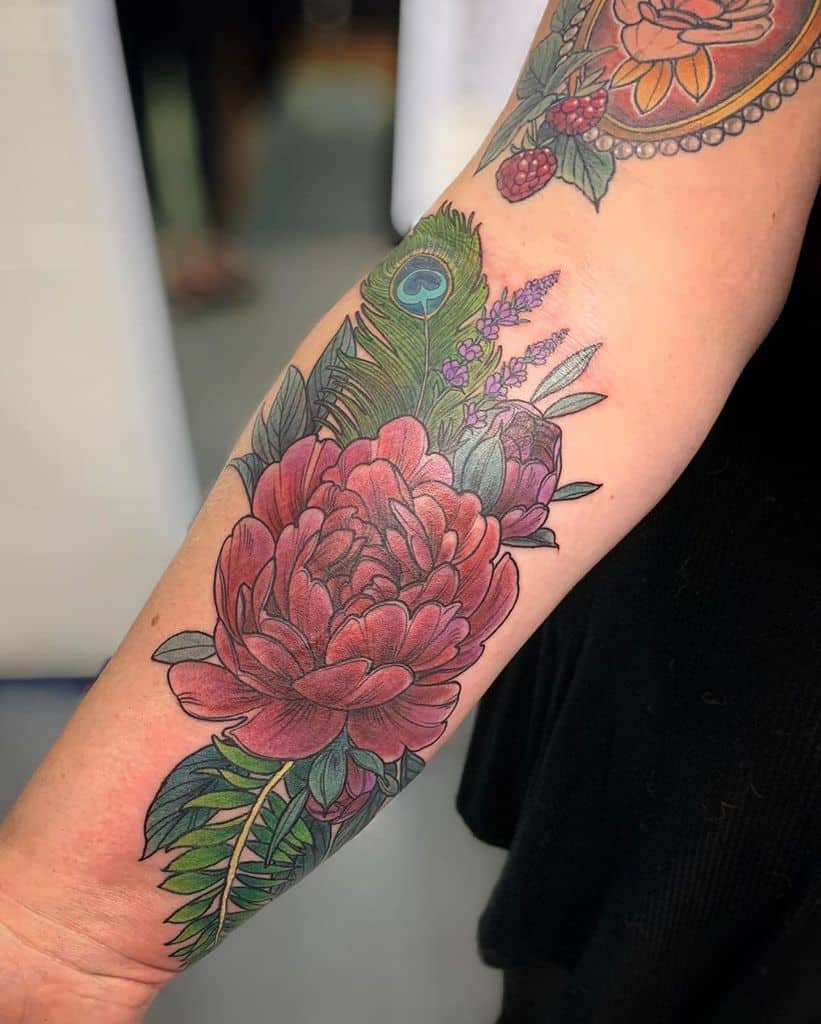 Colorful forearm tattoo featuring a large red peony, a detailed peacock feather, and lavender flowers with vibrant shading and fine linework.