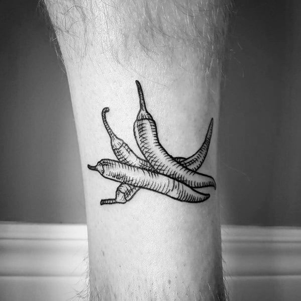Black ink chili pepper tattoo featuring three peppers with fine line shading and a hand-drawn style, creating a bold yet minimalist design.