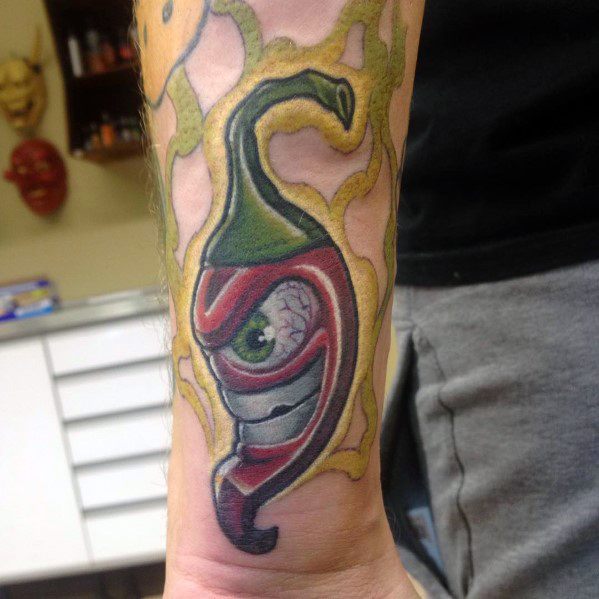 Surreal chili pepper tattoo with a sinister eye and sharp teeth, surrounded by electric energy, creating a bold and eerie design.