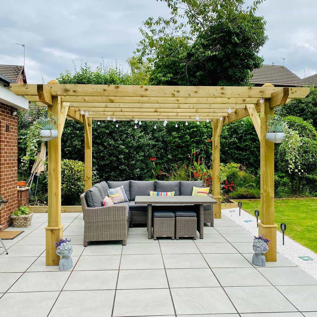 simple wood pergola with wicker furniture and string lights
