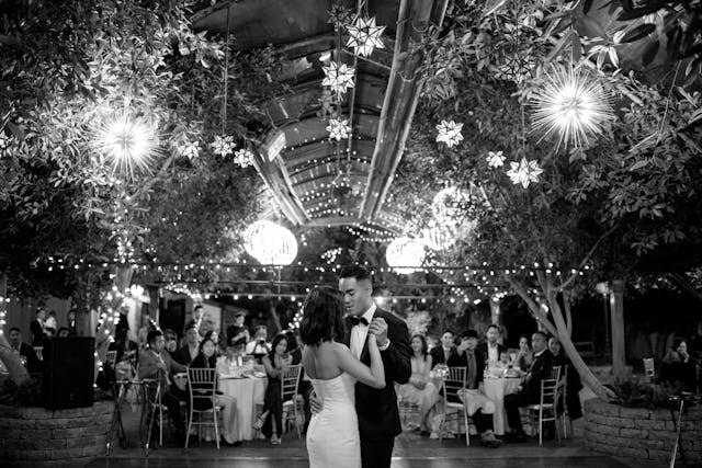 Black and White photo of a bride and groom in front of their party. A guide to groom's wedding attire