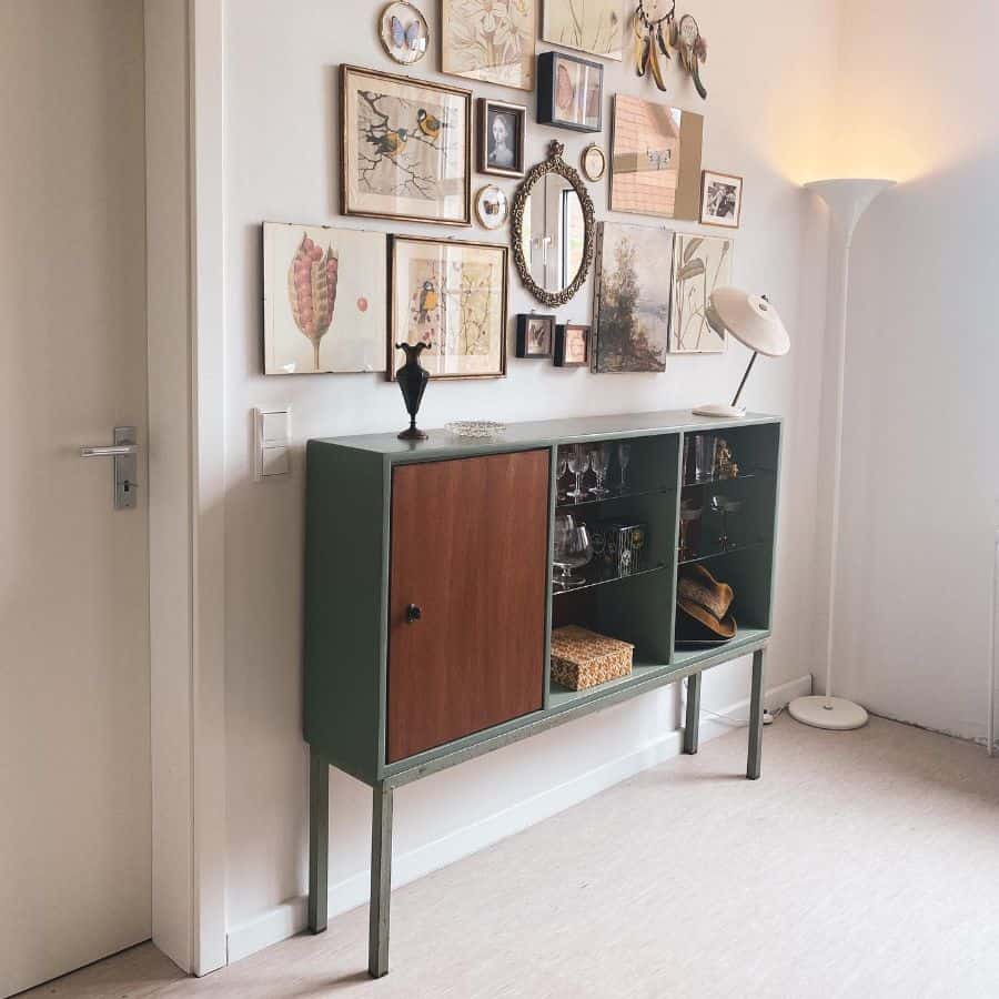 photos and art hanging on walls above green cabinet 