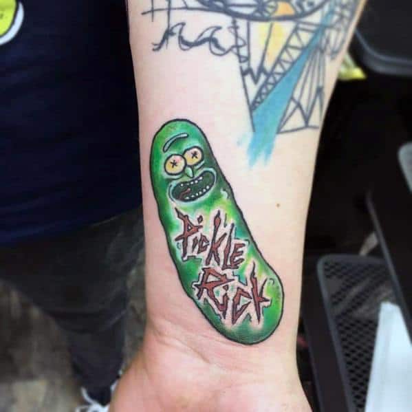 Pickle Rick tattoo with bold green shading and graffiti-style 'Pickle Rick' text, placed on the wrist for a fun and edgy look.