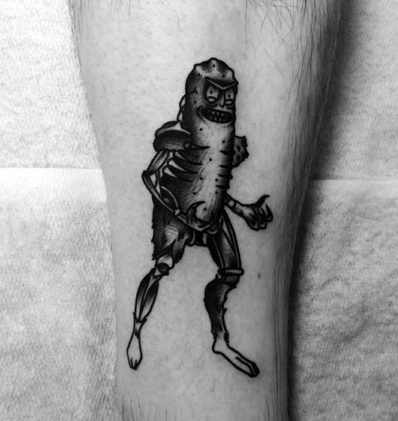 Black and grey Pickle Rick cyborg tattoo with detailed shading, sharp contrasts, and an intense pose, placed on the lower leg.
