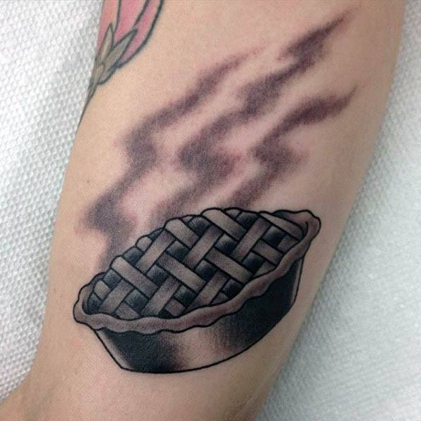 Black and grey steaming pie tattoo with a lattice crust, featuring bold shading for a classic and timeless design
