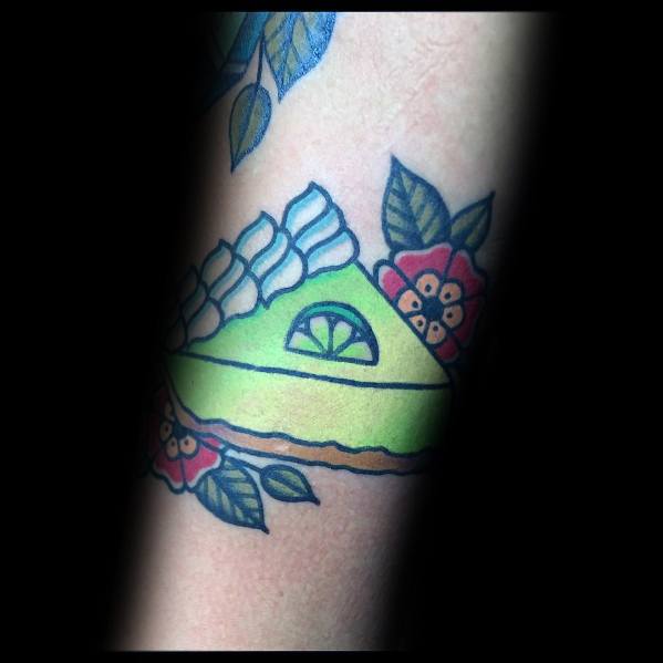 Bright key lime pie tattoo with whipped cream, a lime slice, and floral accents, blending bold colors with a classic traditional tattoo style