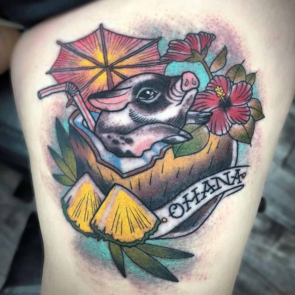 Colorful 'Ohana' tattoo featuring a pig in a coconut drink with hibiscus flowers and pineapples, symbolizing family, fun, and Hawaiian vibes.