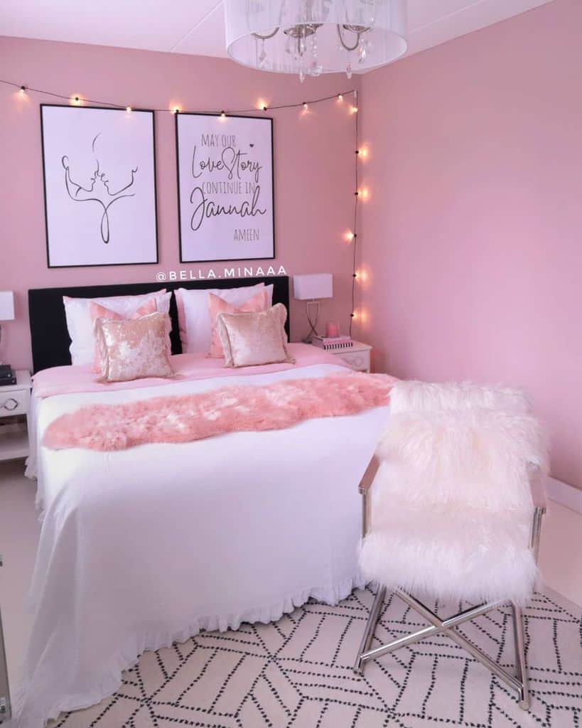 Cozy pink bedroom with a white bed, fluffy pink pillows, and string lights above framed wall art
