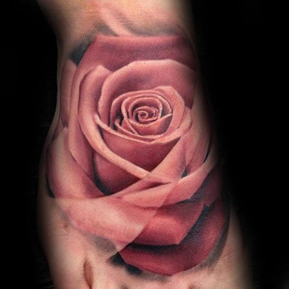 Close-up of a realistic rose tattoo on skin, featuring detailed pink petals and dark shading