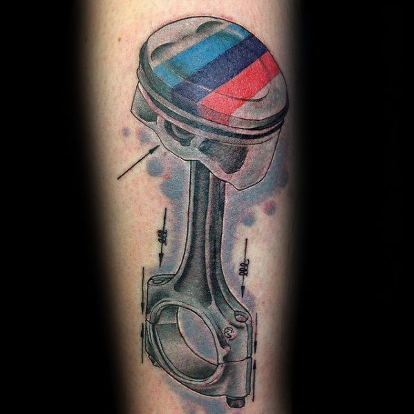 Realistic BMW piston tattoo on forearm, featuring M tricolor stripes and fine mechanical details for a bold automotive-inspired design.