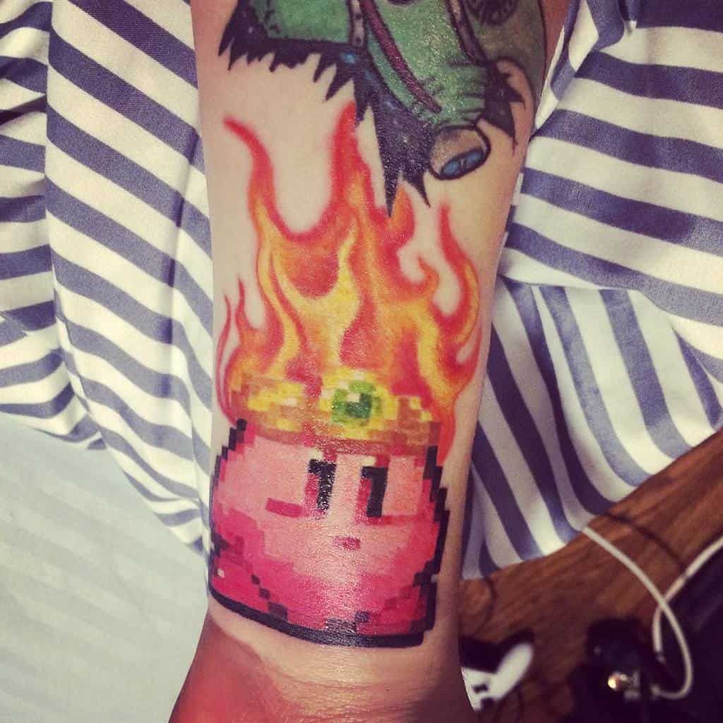 Pixel art-style Kirby tattoo in Fire form, with flames rising from his crown
