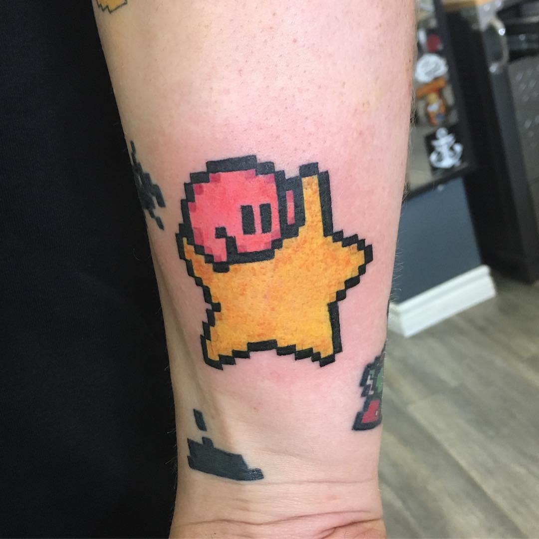 Pixel art-style Kirby tattoo riding a yellow Warp Star