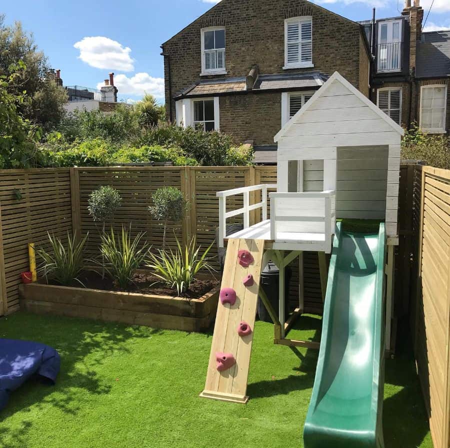 white playhouse with slide backyard