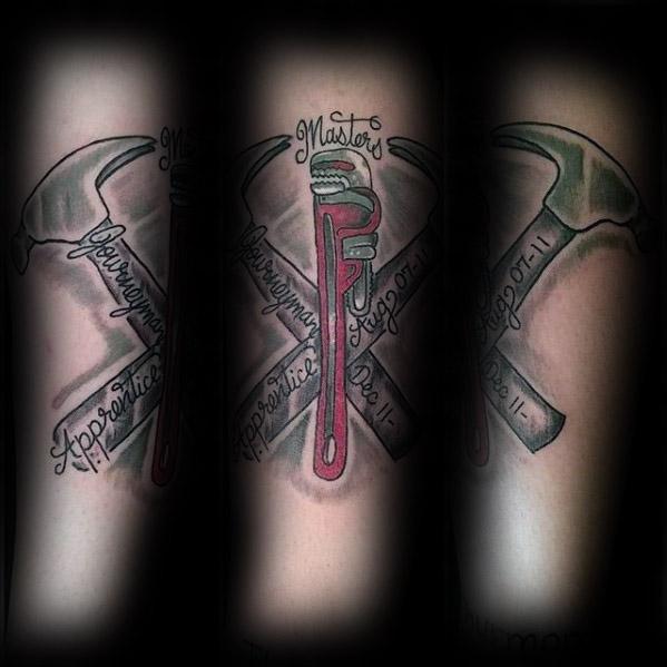 Tattoo of a red pipe wrench crossed with a hammer, with banners reading Apprentice, Journeyman, and Masters wrapped around the tools.