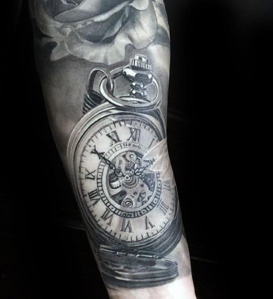 A realistic pocket watch tattoo with Roman numerals and gears on a forearm