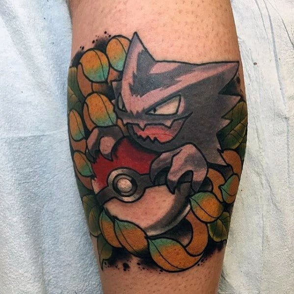 Bold Haunter tattoo gripping a Pokeball, surrounded by vibrant orange and green leaves with dark shadows for a spooky yet colorful vibe.
