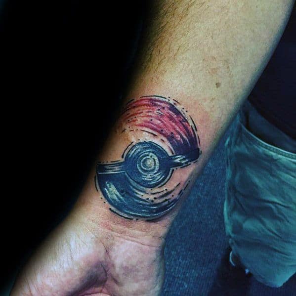 Pokeball tattoo with a painterly brushstroke effect in red and black, creating a dynamic swirling motion on the wrist.