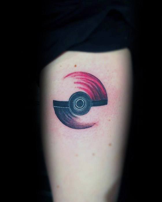 Stylized Pokeball tattoo with red and black brushstroke swirl design, creating a sleek, abstract look on the upper arm.