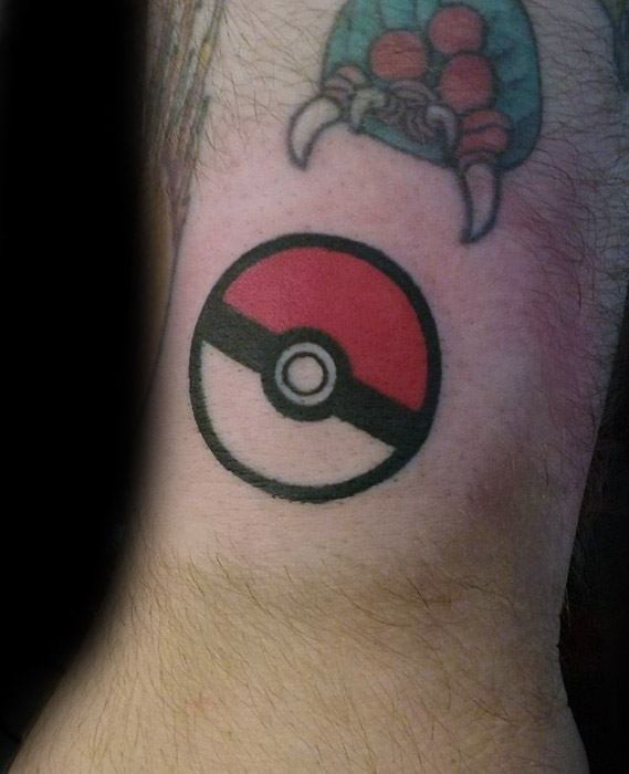 Simple Pokeball tattoo with bold black outlines and solid red fill, offering a clean and classic design on the inner arm.