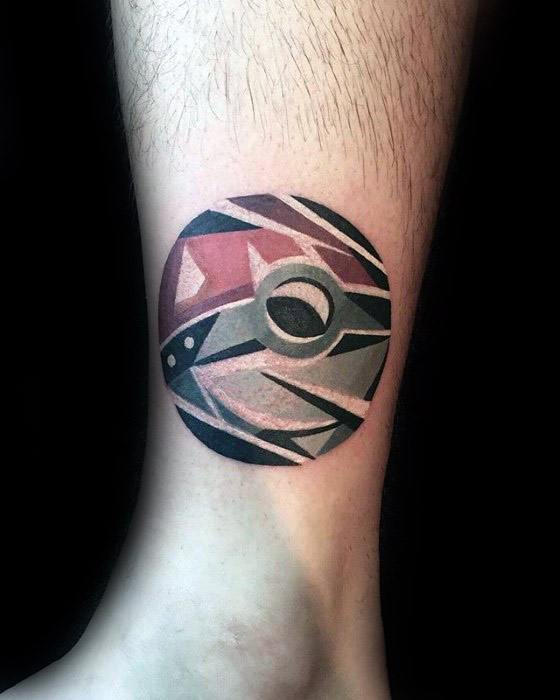 Abstract Pokeball tattoo with geometric patterns and bold shading in red, black, and gray, creating a modern artistic look above the ankle.