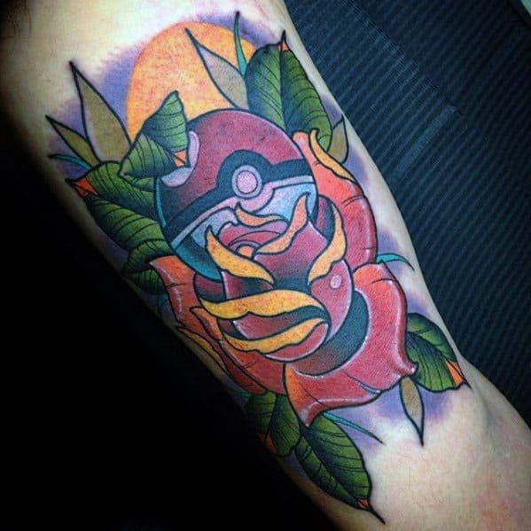 Traditional-style Pokeball tattoo framed by a bold red rose, green leaves, and warm sunset tones, blending classic and modern elements on the arm.