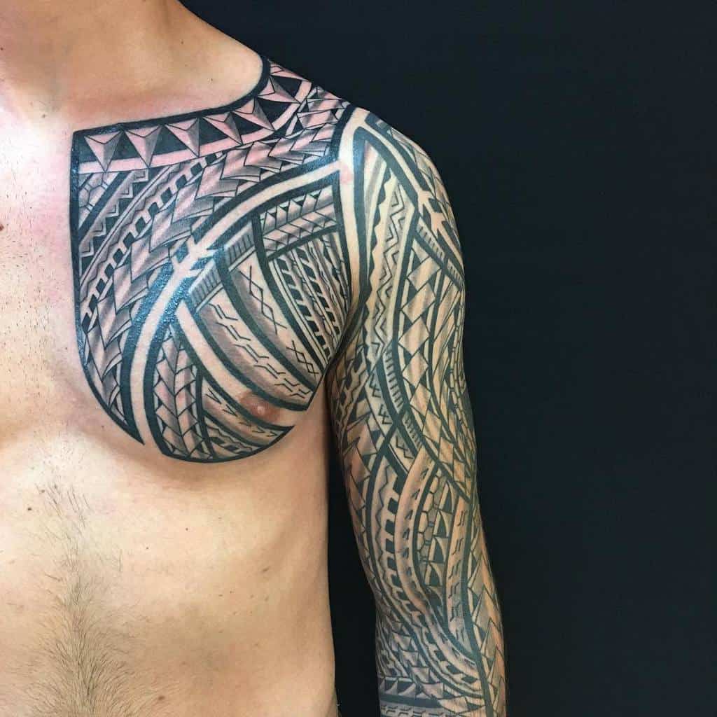 Polynesian full sleeve and chest tattoo with intricate black geometric patterns, bold lines, and detailed tribal elements