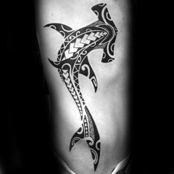 Polynesian hammerhead shark tattoo on ribcage with bold tribal patterns symbolizing protection, adaptability, and warrior strength.