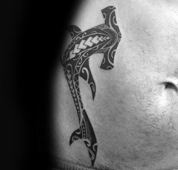 Polynesian hammerhead shark tattoo on side torso with bold tribal designs symbolizing protection, strength, and connection to heritage.