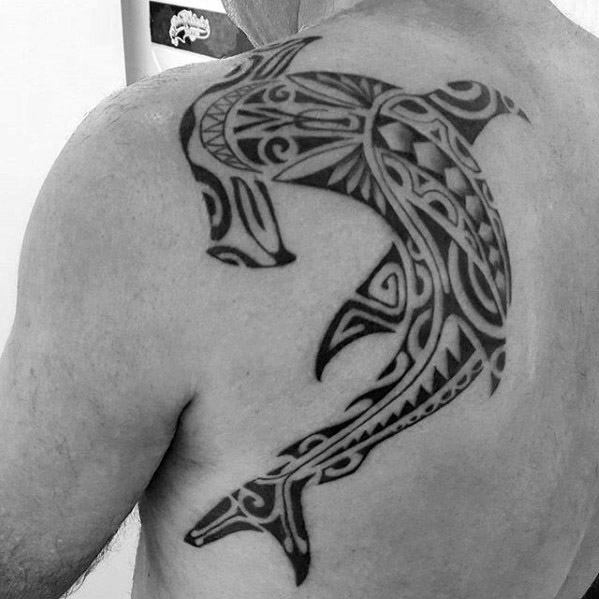 Polynesian shark tattoo on upper back with flowing tribal designs symbolizing courage, guidance, and deep connection to ocean traditions.