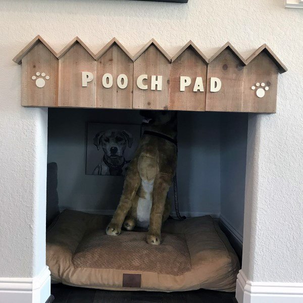 small dog house with cushion and dog wall art
