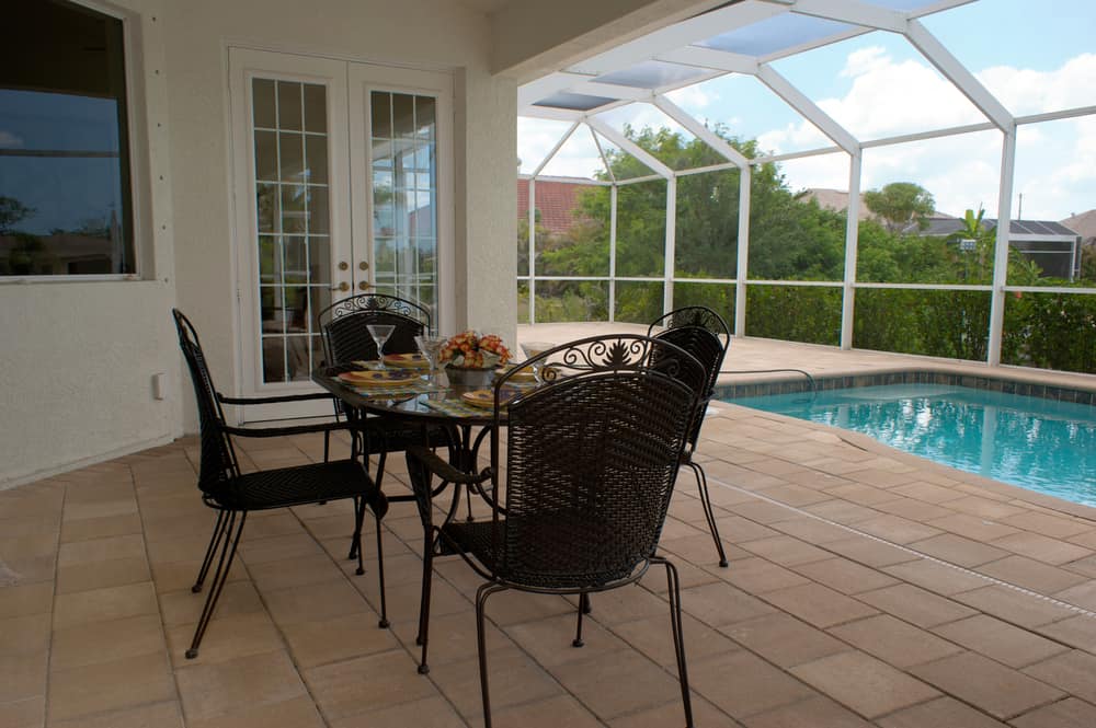 pool enclosed patio pavers black table and chairs