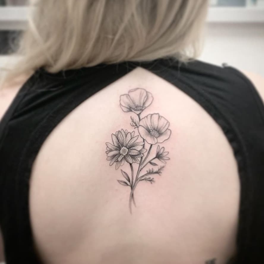 Upper back tattoo black and grey shading poppy daisy bouquet