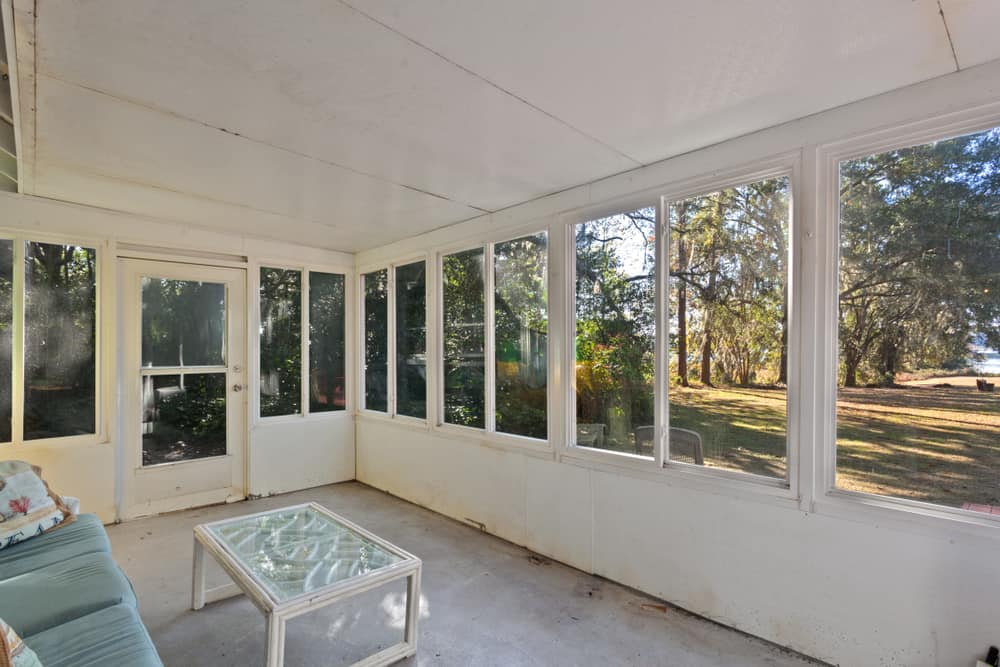 simple enclosed patio concrete floors blue couch glass top table 