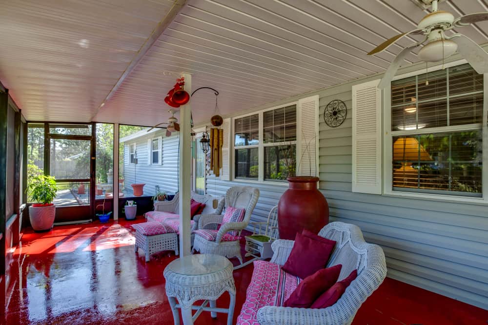 enclosed patio painted red floor white wicker furniture 