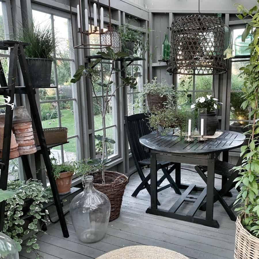 porch greenhouse conservatory black table and chairs candles pot plants wood deck