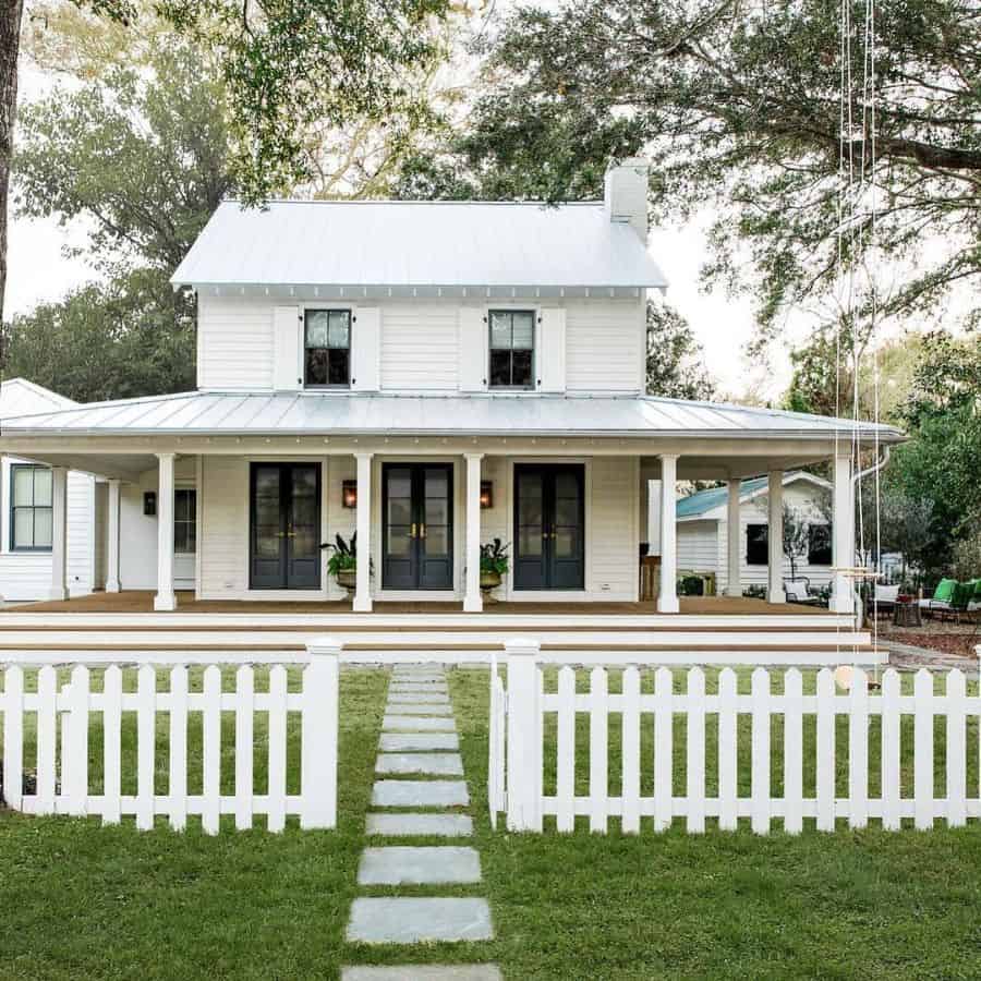classic american home with white picket fence and wraparound porch 