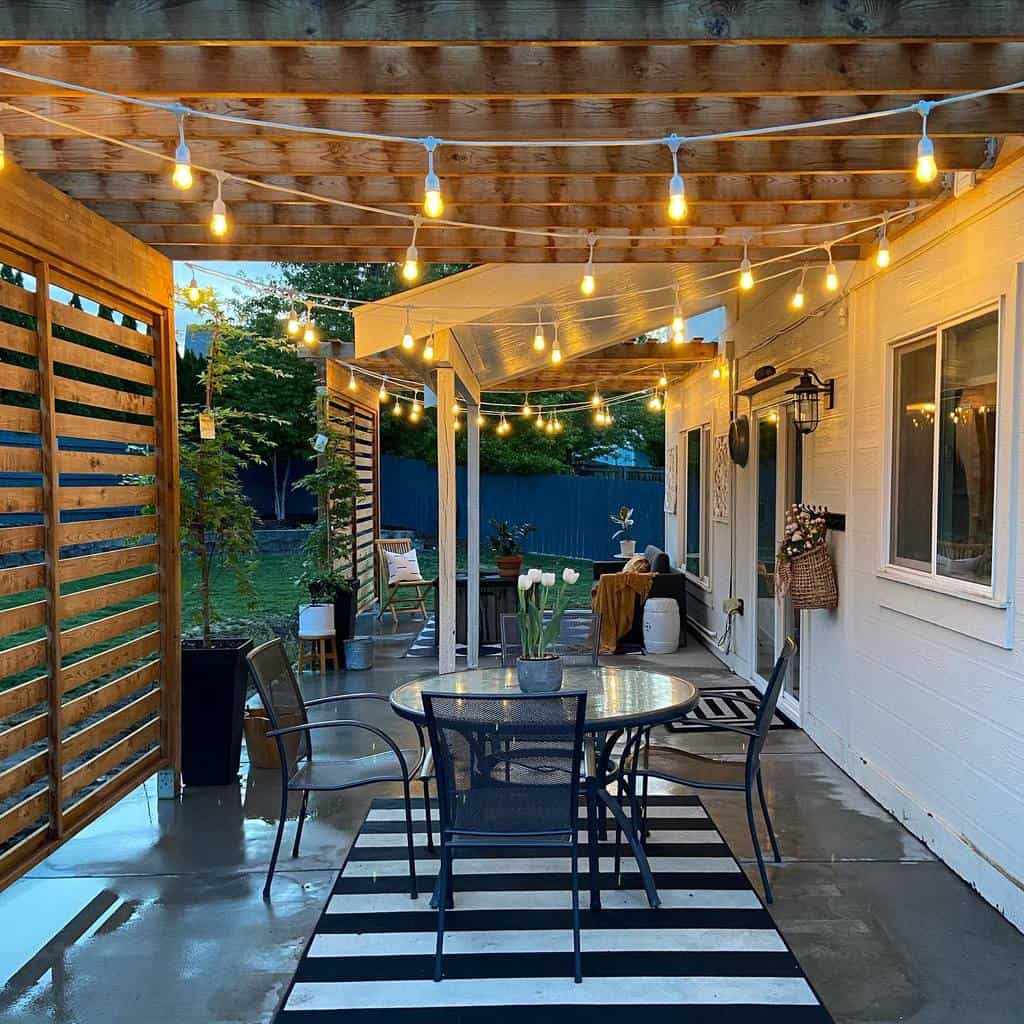 backyard concrete deck with wood pergola and dining table and chairs