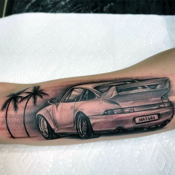 Detailed Porsche tattoo on the forearm featuring palm trees and a personalized license plate, evoking a tropical driving vibe.