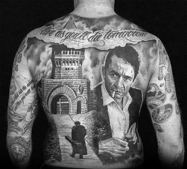 Tattooed back featuring Johnny Cash, a castle, and script at the top